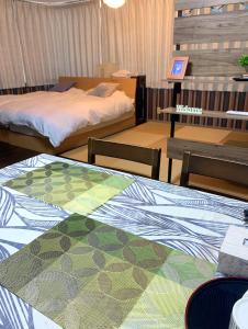 大阪市にあるYiyihouse shinsaibashiのベッドルーム1室(ベッド2台、テーブル、椅子付)