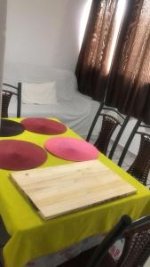 a table with a yellow and red table cloth and chairs at Apartamento no terreo in Natal