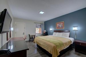 een hotelkamer met een bed en een flatscreen-tv bij Budget Inn Falls Church in Falls Church