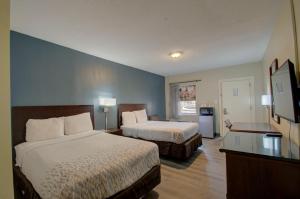 um quarto de hotel com duas camas e uma televisão em Budget Inn Falls Church em Falls Church