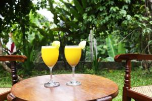 twee glazen sinaasappelsap zittend op een tafel bij Lion Shade Homestay in Katugastota