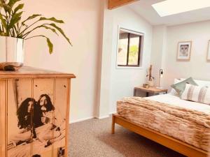 ein Schlafzimmer mit einem Bett und einer Topfpflanze in der Unterkunft Kangarloo Retreat 