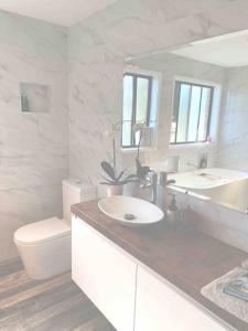 ein weißes Bad mit einem Waschbecken und einem WC in der Unterkunft Kangarloo Retreat 