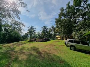 un todoterreno estacionado en un campo de césped con árboles en The Nature's Resort, Hanwella, 