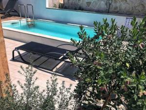 una piscina con una mesa junto a una planta en Holiday home Olive, en Privlaka