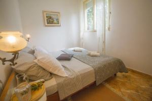Dormitorio pequeño con cama y ventana en Apartments Arc - 5 M From Beach, en Poljica