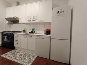 uma cozinha com armários brancos e um frigorífico em Rooms in Heart of Gothic em Barcelona