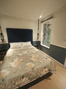 a bedroom with a large bed with a blue headboard at Seven Seas Cote d'Azur, Jomtien Beach Pattaya in Na Jomtien