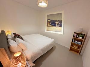 a bedroom with a bed and a painting on the wall at Coral Cottage Beach House @ Phang Nga in Thai Muang