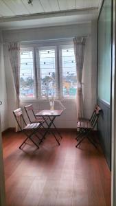 a room with a table and chairs and windows at Chất home in Da Lat +17 photos