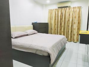 ein Schlafzimmer mit einem Bett und einem gelben Vorhang in der Unterkunft Kapar Nala 34A /3 Rooms/4-8 pax in Kapar