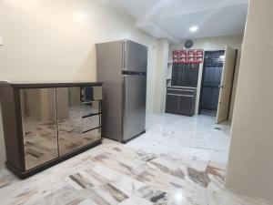 uma cozinha com um frigorífico de aço inoxidável num quarto em Kapar Nala 34A /3 Rooms/4-8 pax em Kapar