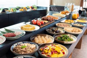 uma linha de buffet com muitos tipos diferentes de alimentos em Hotel Ryumeikan Tokyo em Tóquio