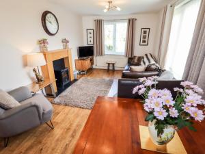 a living room with a vase of flowers on a table at The Flat At Brwyn in Holywell