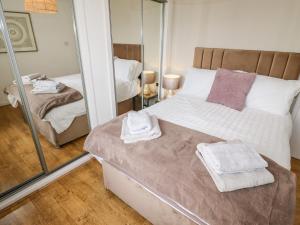 um quarto com uma cama e um espelho grande em The Flat At Brwyn em Holywell