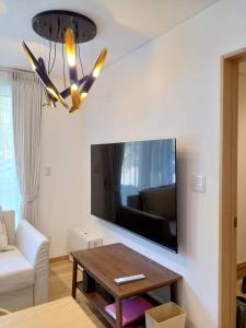 a living room with a large tv and a table at Niseko STREAM Villas in Rankoshi