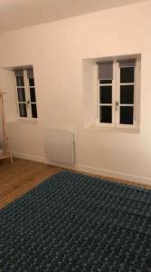 an empty room with two windows and a rug at Maison centre historique in Laval