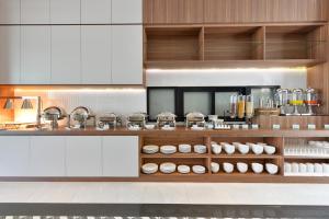 a kitchen with white cabinets and a counter with food at Grace Patong Hotel in Patong Beach