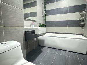 a bathroom with a white tub and a toilet at JB City Shopping Mall Apartment in Johor Bahru