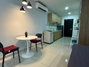 a room with a table and chairs and a kitchen at JB City Shopping Mall Apartment in Johor Bahru