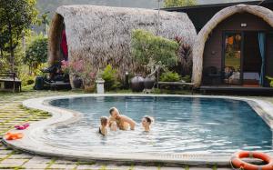 a group of three people in a swimming pool at Green Homestay in Cat Ba