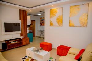 sala de estar con sofá y TV en The View Apartments Kigali, en Kigali