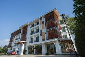 a white building with a balcony on the side of it at MOODs Boutique Hotel in Ban Phayom