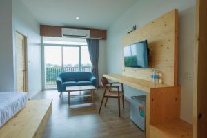 a bedroom with a bed and a desk with a blue chair at MOODs Boutique Hotel in Ban Phayom