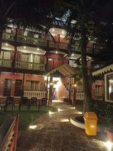 a building with chairs and a tree at night at Blue Sea Beach Resort Malvan in Malvan