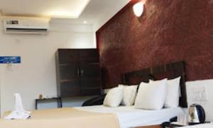 a hotel room with a bed with white pillows at Blue Sea Beach Resort Malvan in Malvan