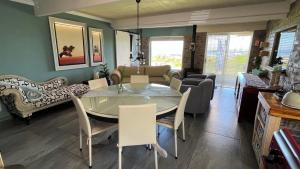 uma sala de jantar e sala de estar com mesa e cadeiras em Seaview Happy place em Bettyʼs Bay