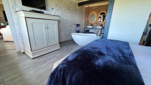 um quarto com uma banheira, um lavatório e uma cama em Seaview Happy place em Bettyʼs Bay