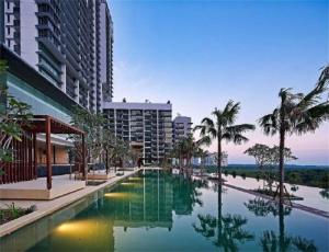 依斯干達公主城的住宿－Iskandar Residences 2BR 5pax 5 mins Legoland Wi-Fi Sky Pool 360，一座棕榈树游泳池和一座建筑