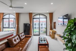 a living room with a couch and a table at 222 ROSÉ Hotel in Phú Quốc
