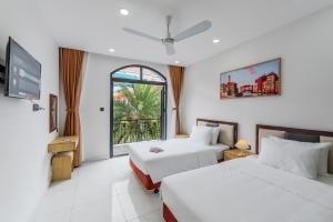 a hotel room with two beds and a window at 222 ROSÉ Hotel in Phu Quoc