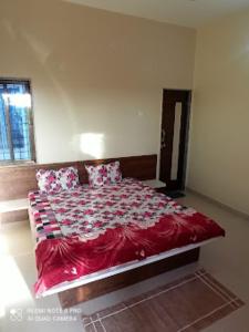 1 dormitorio con 1 cama grande con sábanas y almohadas rojas en HOTEL ADIRAJ PALACE AND LODGING, Shani Shingnapur, en Sonai