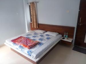 1 dormitorio con 1 cama con cabecero de madera en HOTEL ADIRAJ PALACE AND LODGING, Shani Shingnapur, en Sonai
