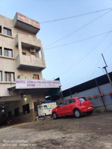 un coche rojo estacionado frente a un edificio en HOTEL ADIRAJ PALACE AND LODGING, Shani Shingnapur, en Sonai