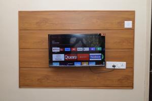 a tv on top of a wooden drawer at Hotel laxminarayan in Shirdi