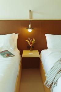 a hotel room with two beds and a table with flowers at Hotel Lucine in Galveston