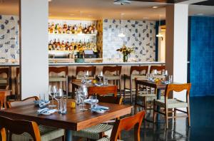 un restaurante con mesas y sillas de madera y un bar en Hotel Lucine, en Galveston