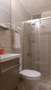 a bathroom with a shower and a toilet and a sink at Beyaz Melek Hotel in Antalya