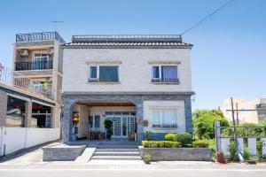 a brick building with a door and a porch at Sea Travel in Xiaoliuqiu