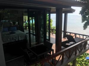 a room with a bed and chairs on a deck at Suncliff Resort in Haad Rin