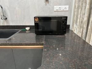 a microwave sitting on a counter next to a sink at Passaddhi Serviced Apartment T2 in Mysore