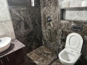 a bathroom with a shower and a toilet and a sink at Passaddhi Serviced Apartment T2 in Mysore