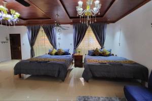 a large bedroom with two beds and a chandelier at CL Homestay in Sen Monorom