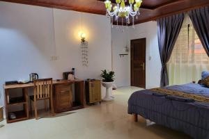 a bedroom with a bed and a desk and a chandelier at CL Homestay in Senmonorom