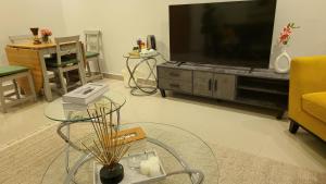 un soggiorno con TV a schermo piatto su un centro di intrattenimento di شقة فاخرة VIP حي الوادي a Riyad