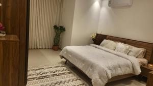 1 dormitorio con 1 cama grande y 1 alfombra en شقة فاخرة VIP حي الوادي en Riad